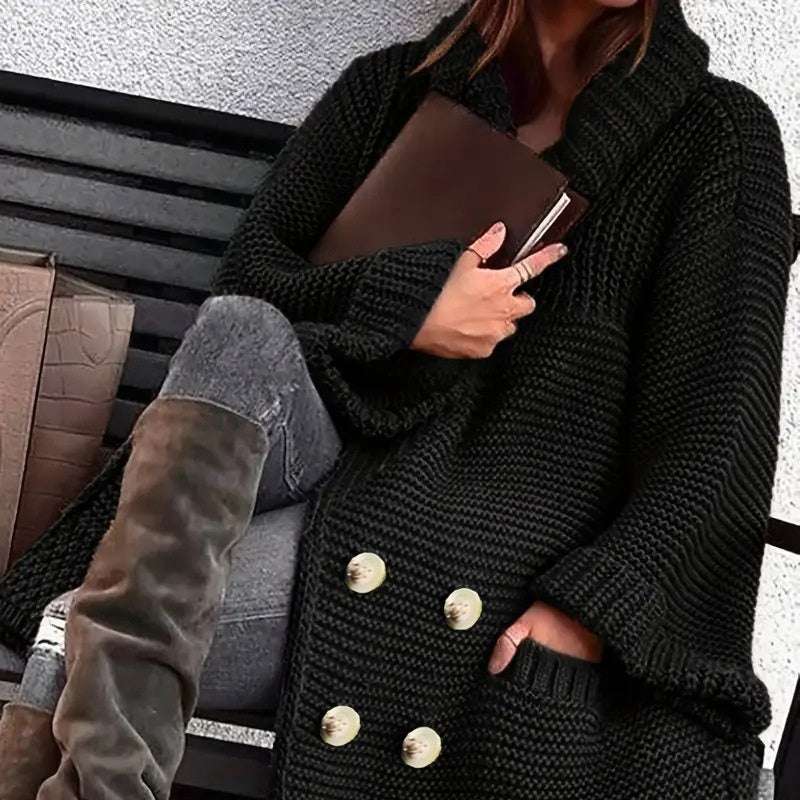 Person wearing a black coat with gold buttons, holding a brown leather book.