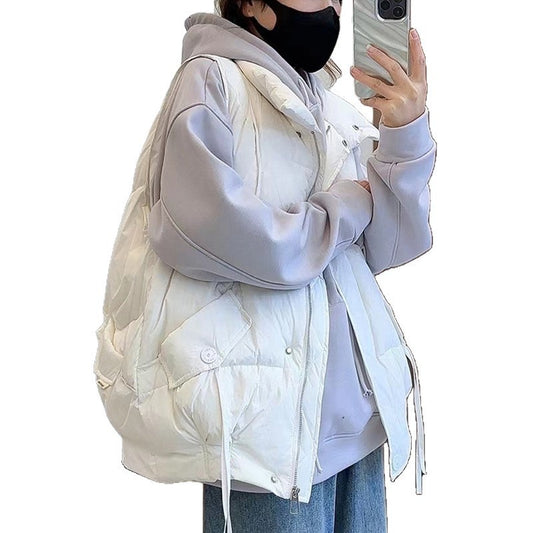 Person wearing a light gray puffer jacket over a white hoodie on a plain background