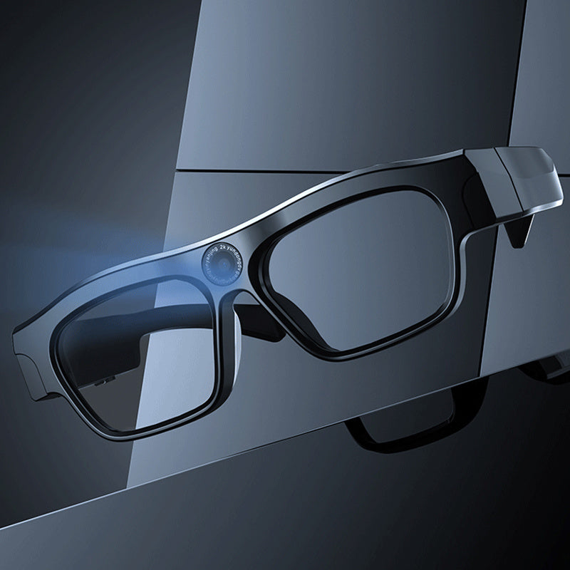 Black 3D glasses on a reflective surface with a dark background