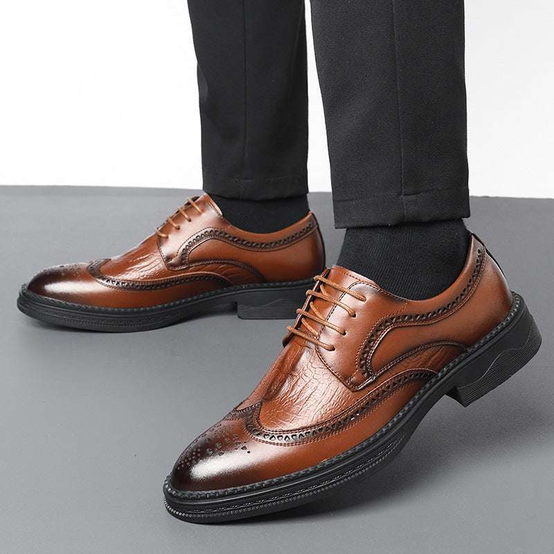 Brown leather dress shoes worn with black socks on a gray background