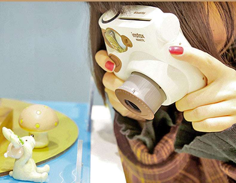 Person holding a white instant camera with a colorful background