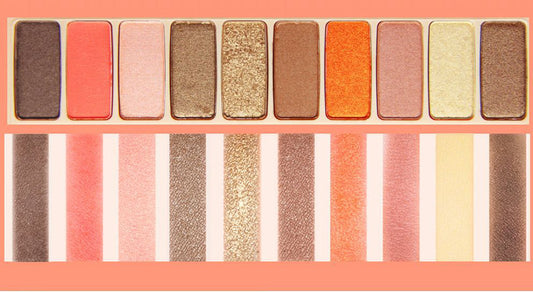 Makeup palette with various eyeshadow colors on a pink background
