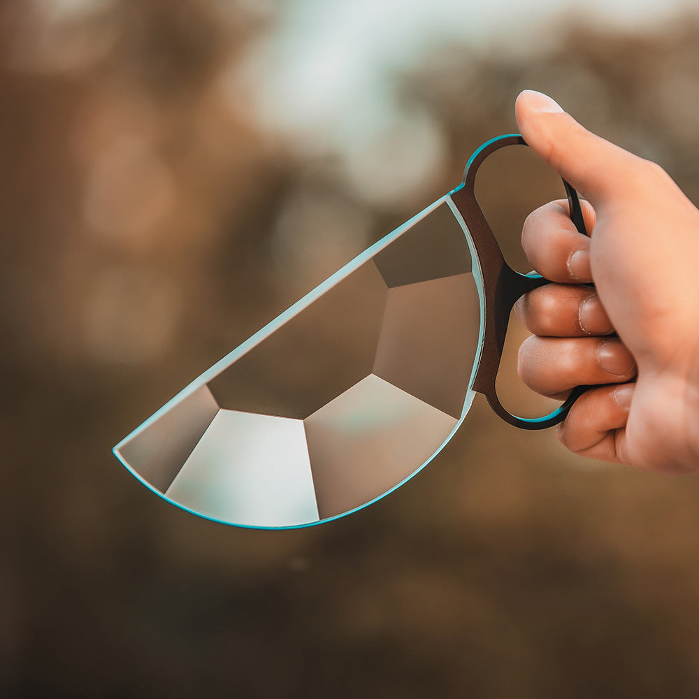 Hand holding a futuristic looking mask with a blurred natural background