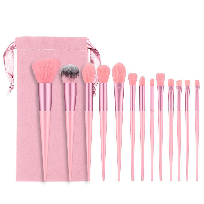 Set of pink makeup brushes with a pink pouch on a white background