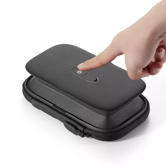 Hand opening a black rectangular case with a button on a white background