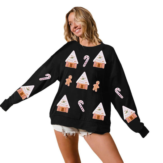 Woman wearing a black sweater with festive patterns on a white background