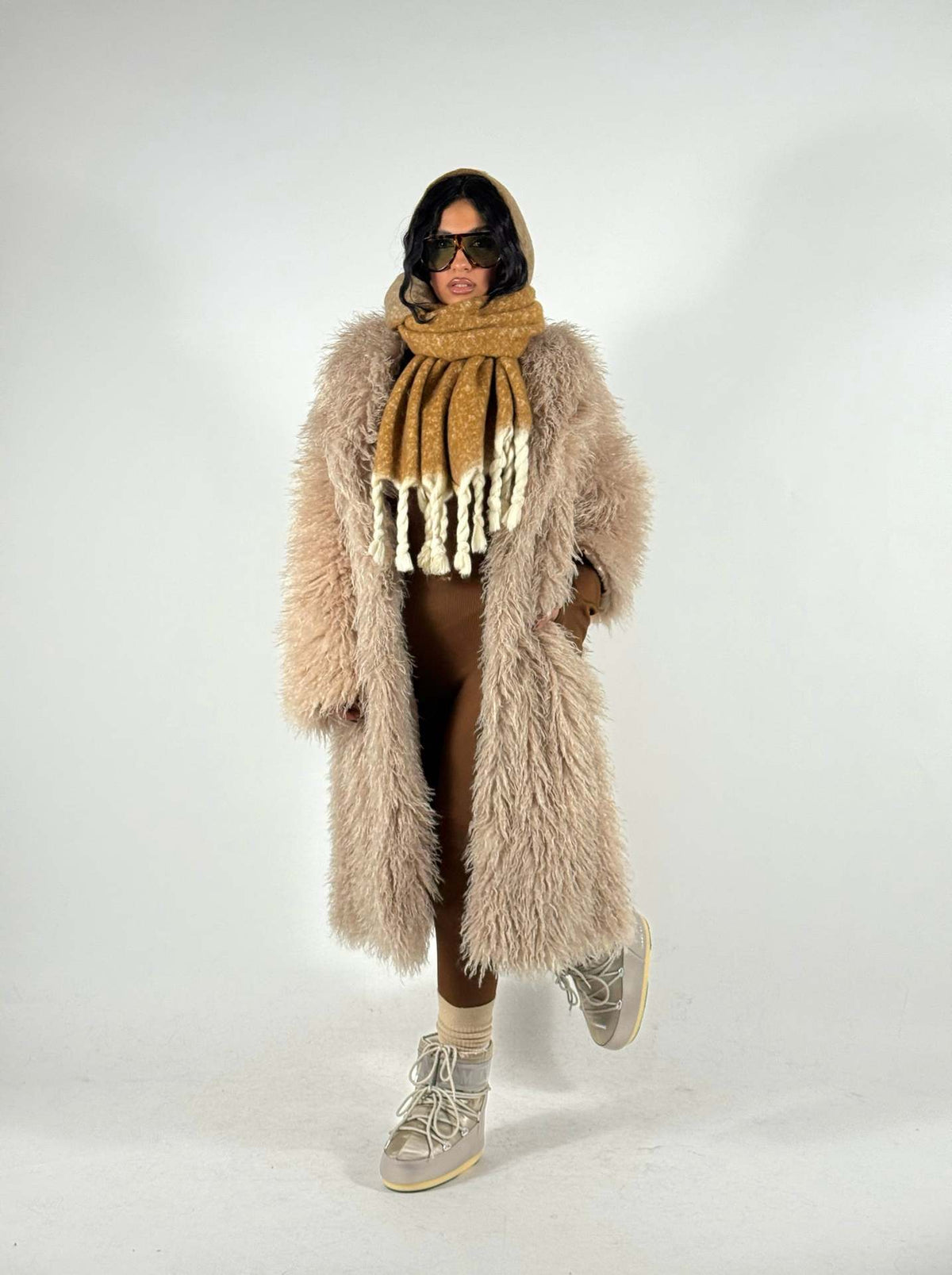 Women’s mid-length faux fur coat, light taupe, hooded, open front, long sleeves.