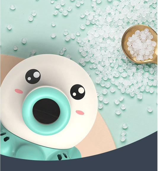 Donut-shaped toy with cartoon face on a light blue background with small white beads.