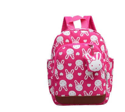 Pink toddler backpack with white bunny pattern, front pocket, padded shoulder straps.