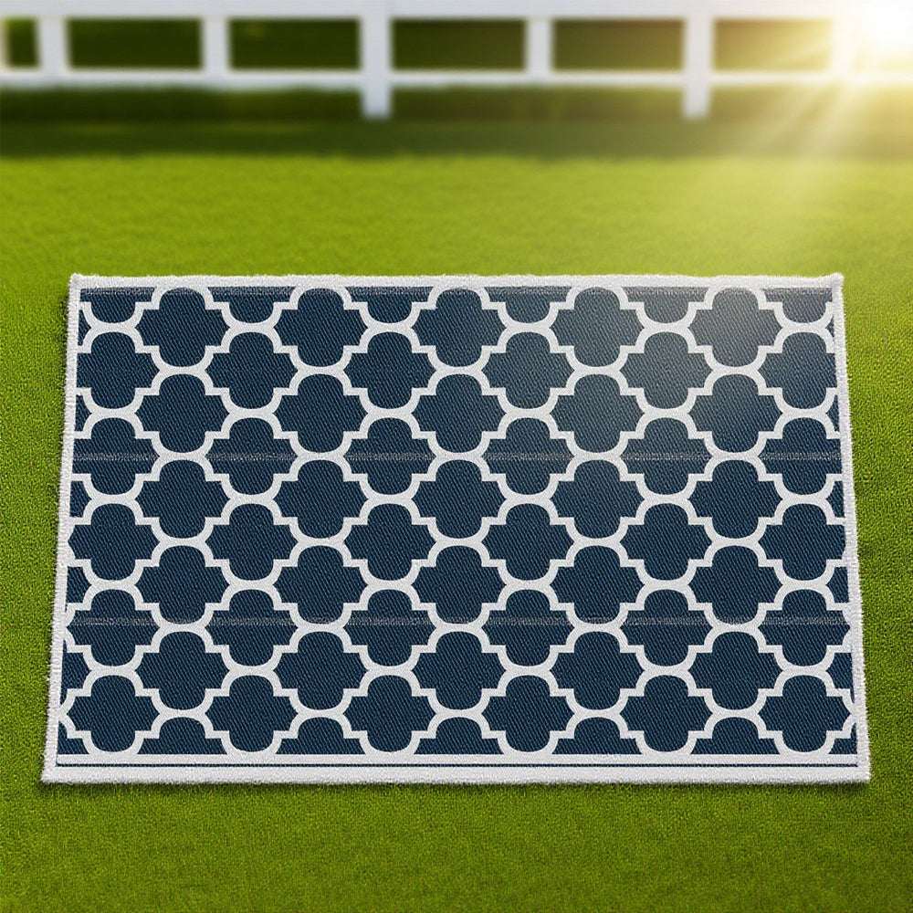 Reversible outdoor rug close-up with navy-and-white quatrefoil pattern and border