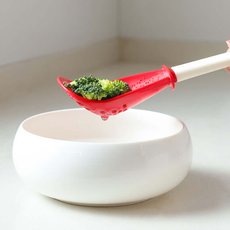 Red perforated cooking spoon with white handle