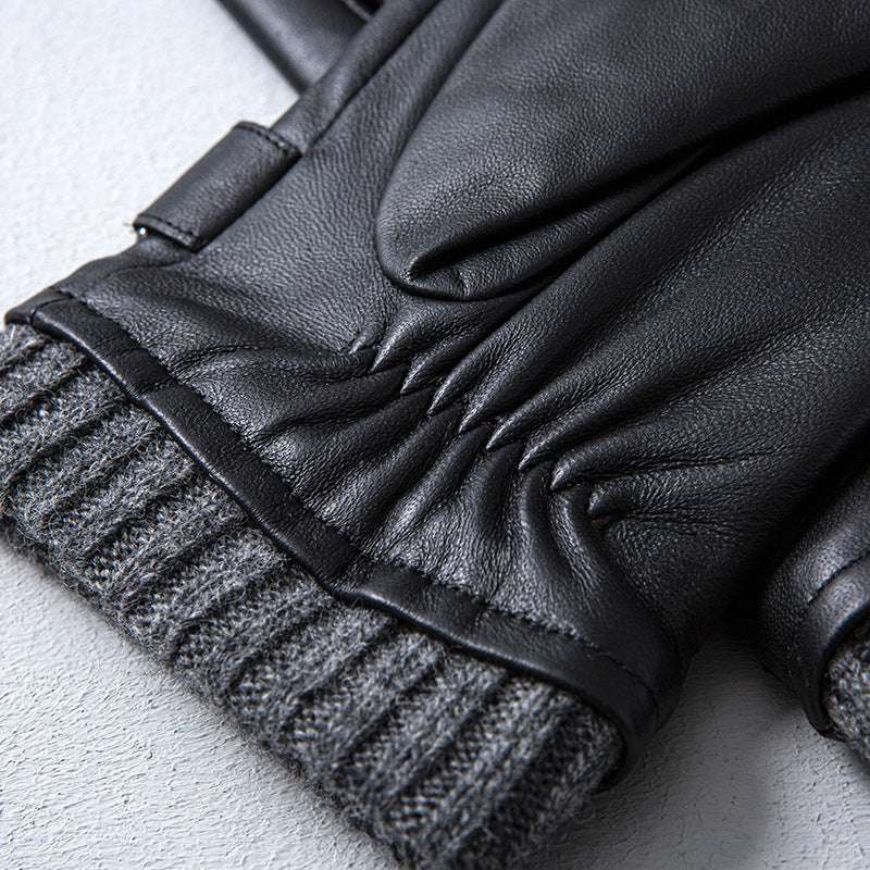 Close-up of black leather gloves with gray ribbed cuffs on a light gray background