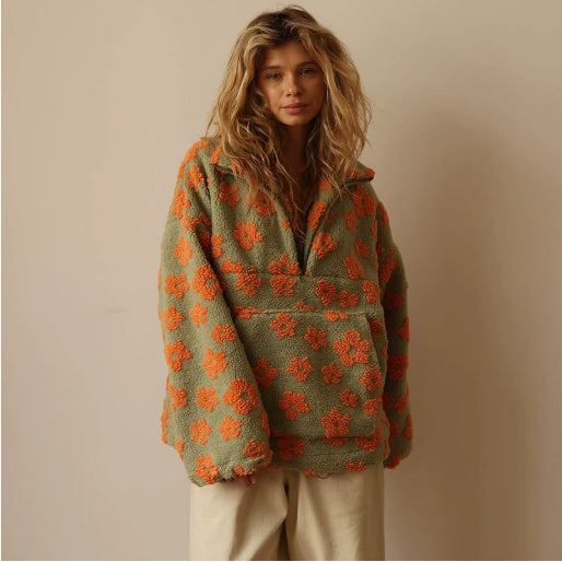 Woman wearing a green and orange floral-patterned jacket against a beige background