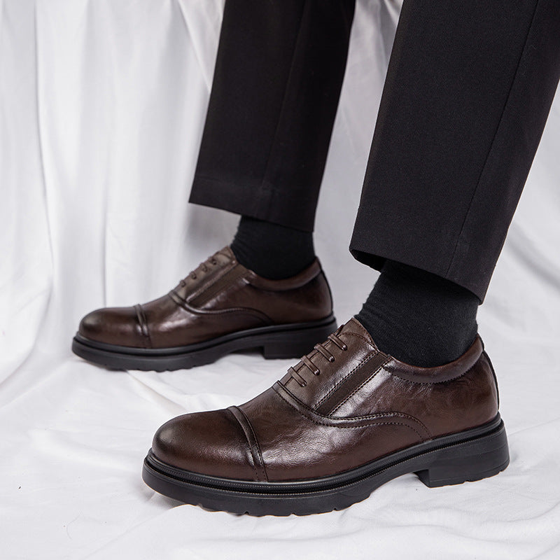 Brown leather dress shoes worn with black pants and socks on a white background