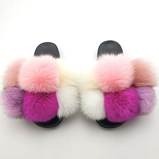 Pair of slides with multicolored fur pom-poms on a white background