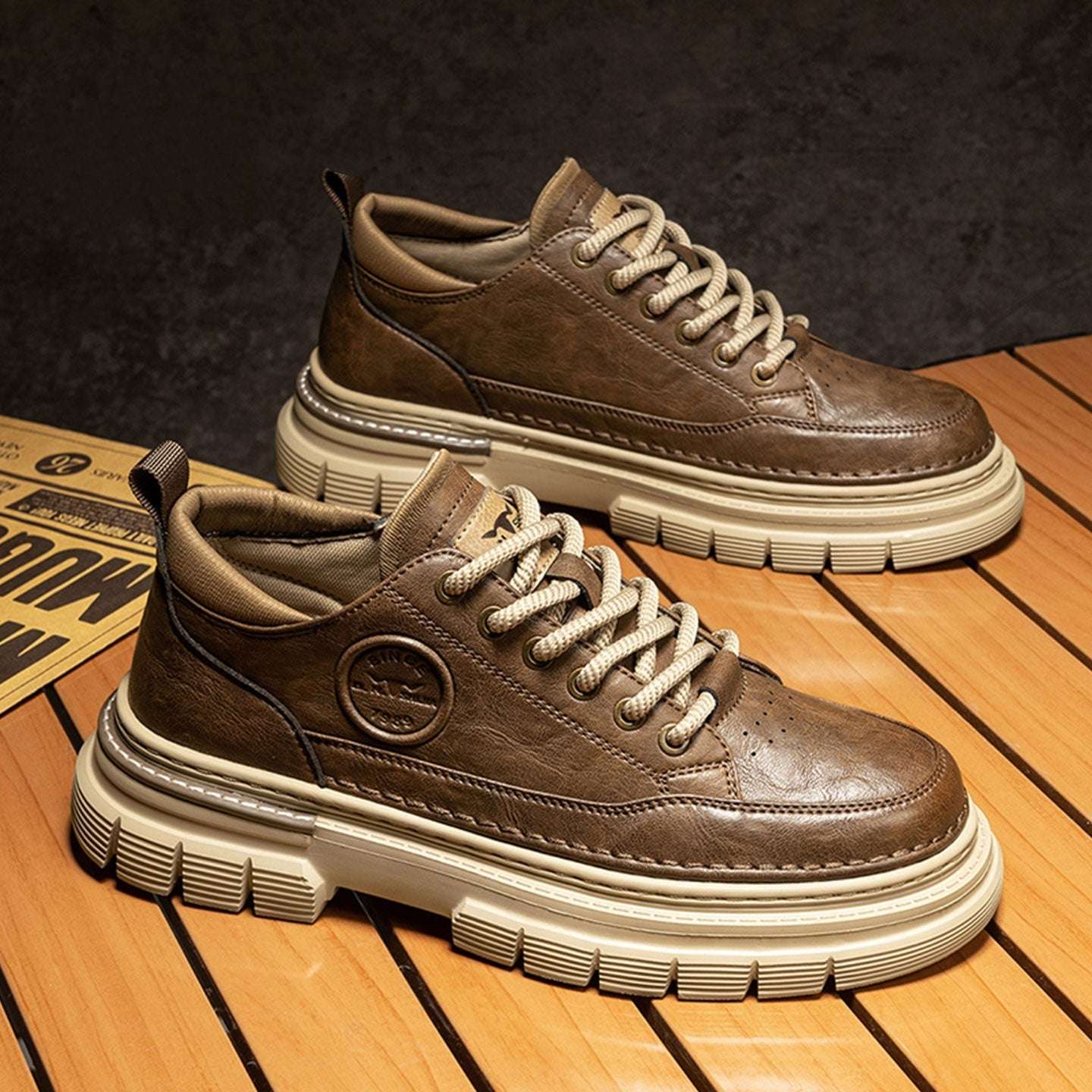 Brown leather sneakers with white soles on a wooden floor