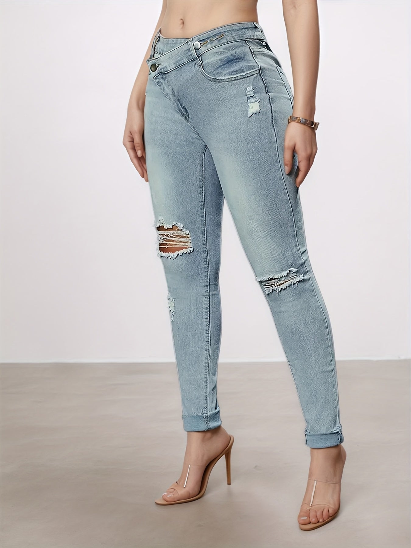 Light blue slim-fit denim leggings with distressed thigh panel and knee rips