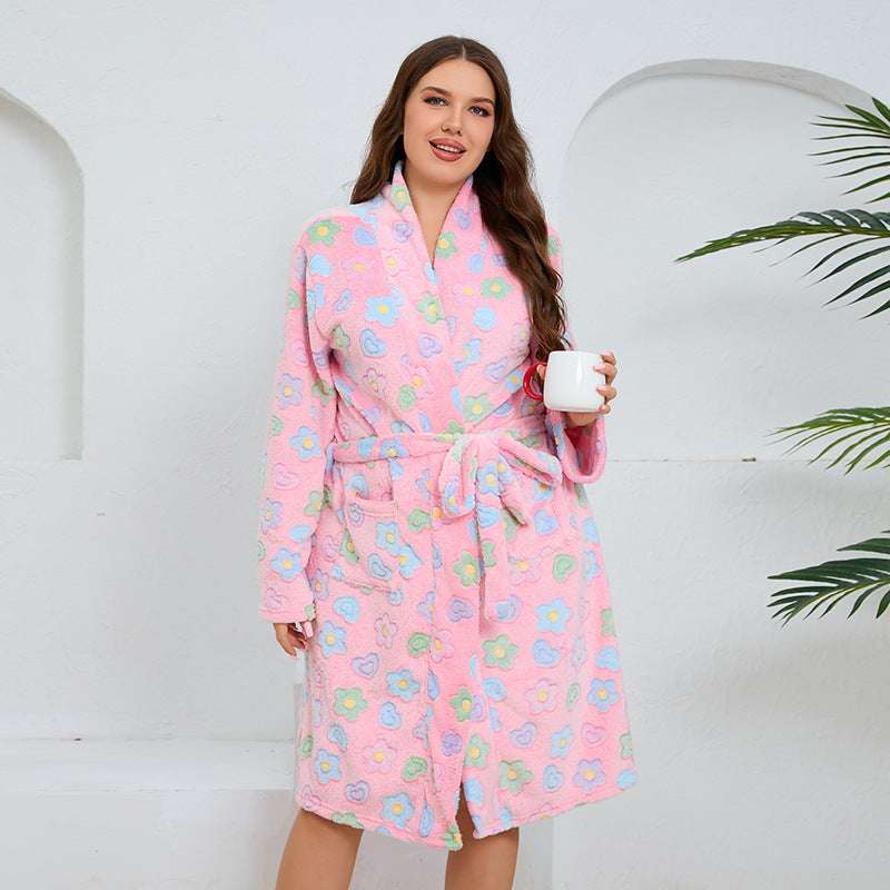 Woman wearing a pink floral robe holding a white mug against a white background
