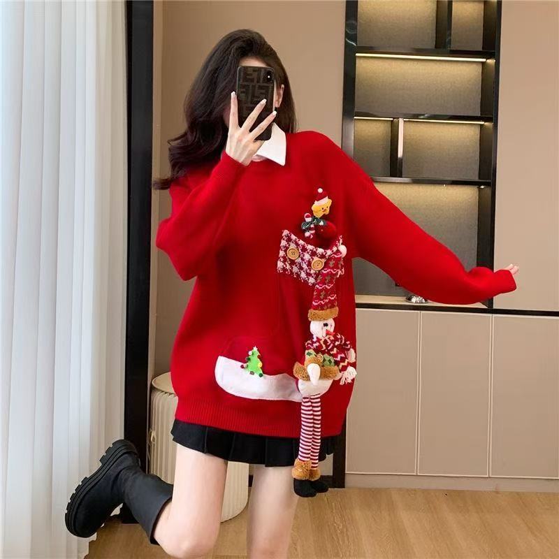Person wearing a red sweater with Christmas-themed decorations in an indoor setting.