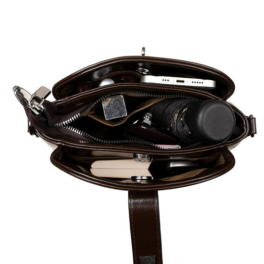 Brown leather crossbody bag with compartments on a white background