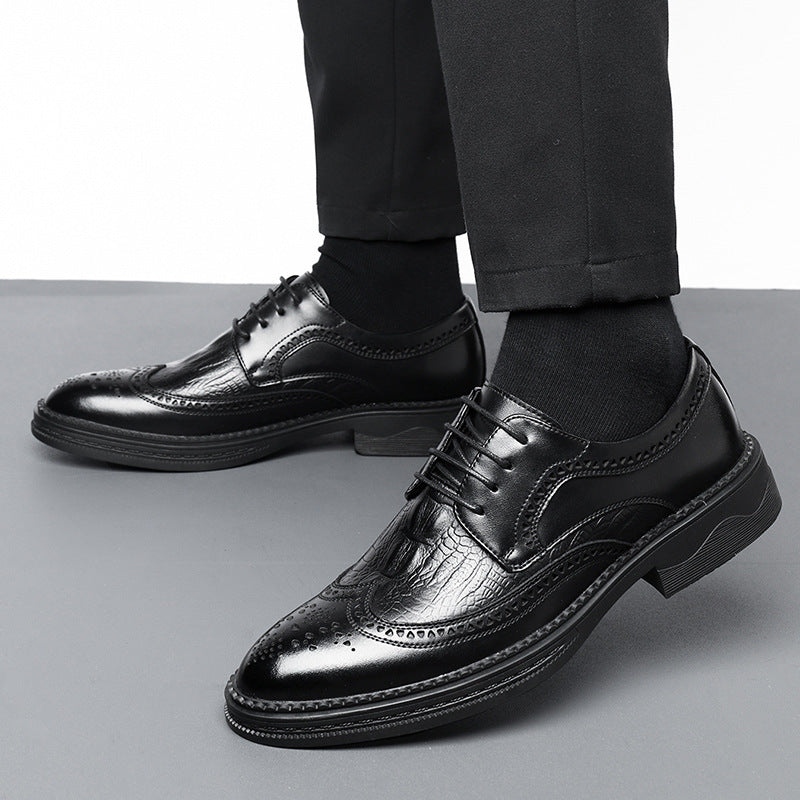 Black leather dress shoes worn with black pants on a gray background