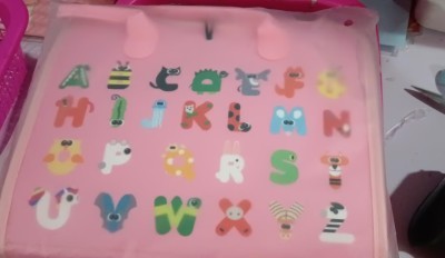 Pink alphabet chart with colorful letters on a pink background