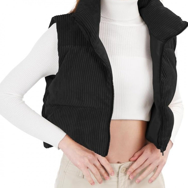 Person wearing a black ribbed vest over a white long-sleeve shirt on a white background