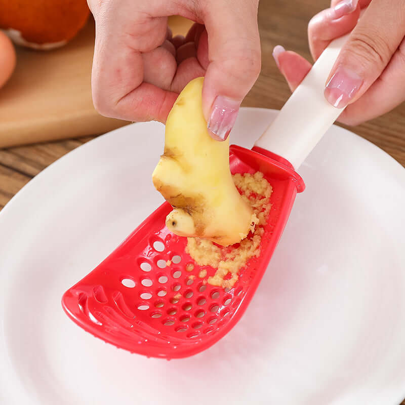 Red perforated cooking spoon with white handle