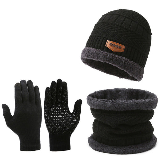 Black knit beanie with gray interior, black gloves, and black knit scarf with gray interior on a white background