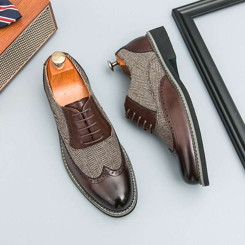Brown and beige dress shoes on a light gray surface with a framed picture and small box in the background.
