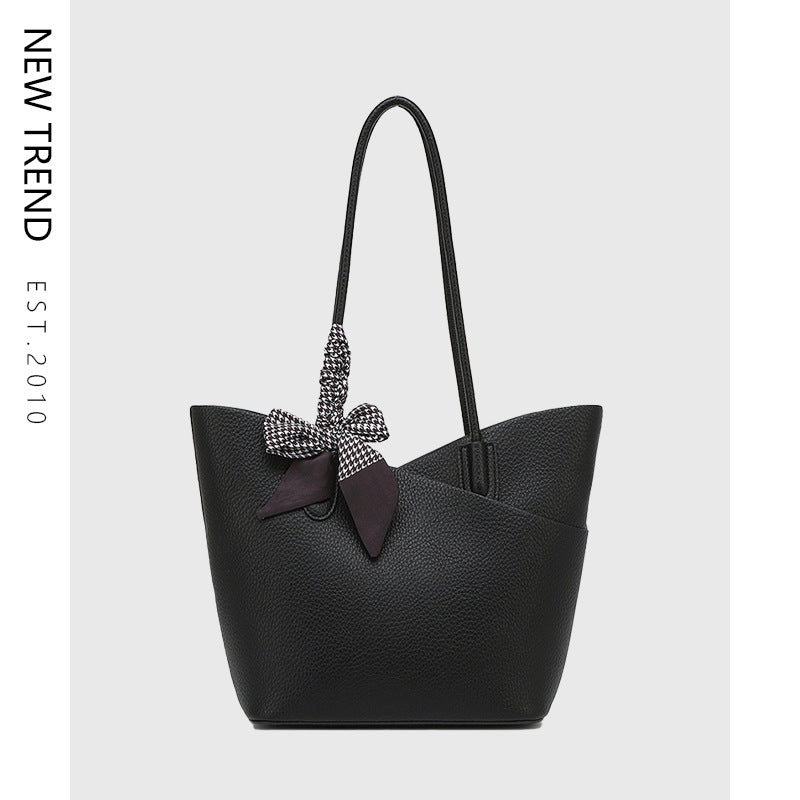 Black large tote handbag with top handles and patterned ribbon bow detail