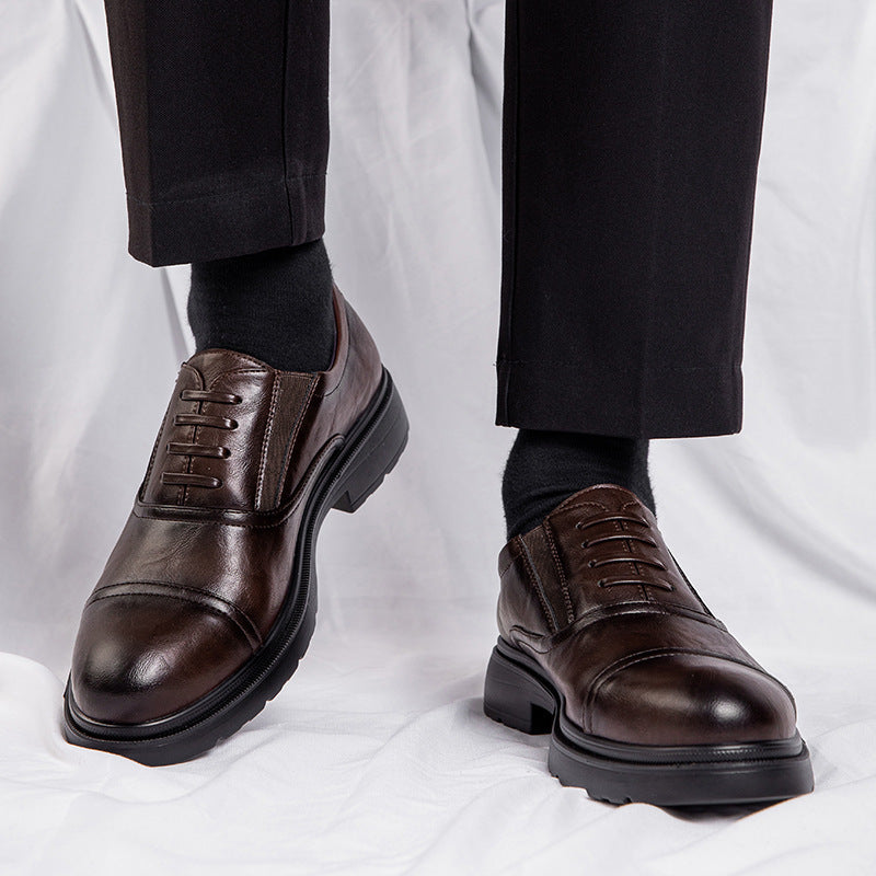 Brown dress shoes worn with black pants and socks on a white background