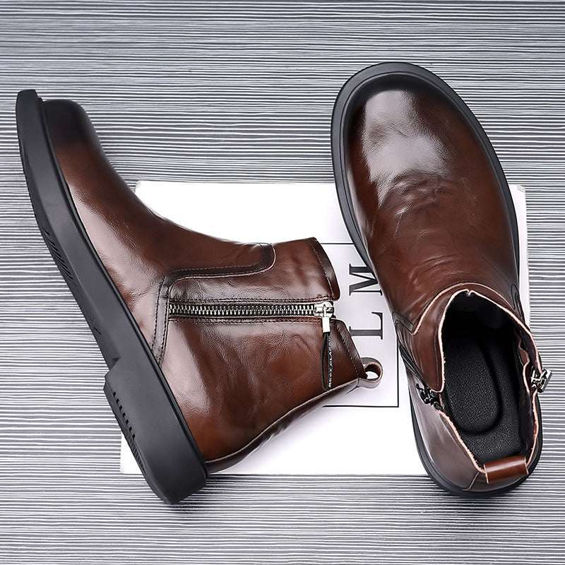 Brown leather boots with zippers on a textured surface