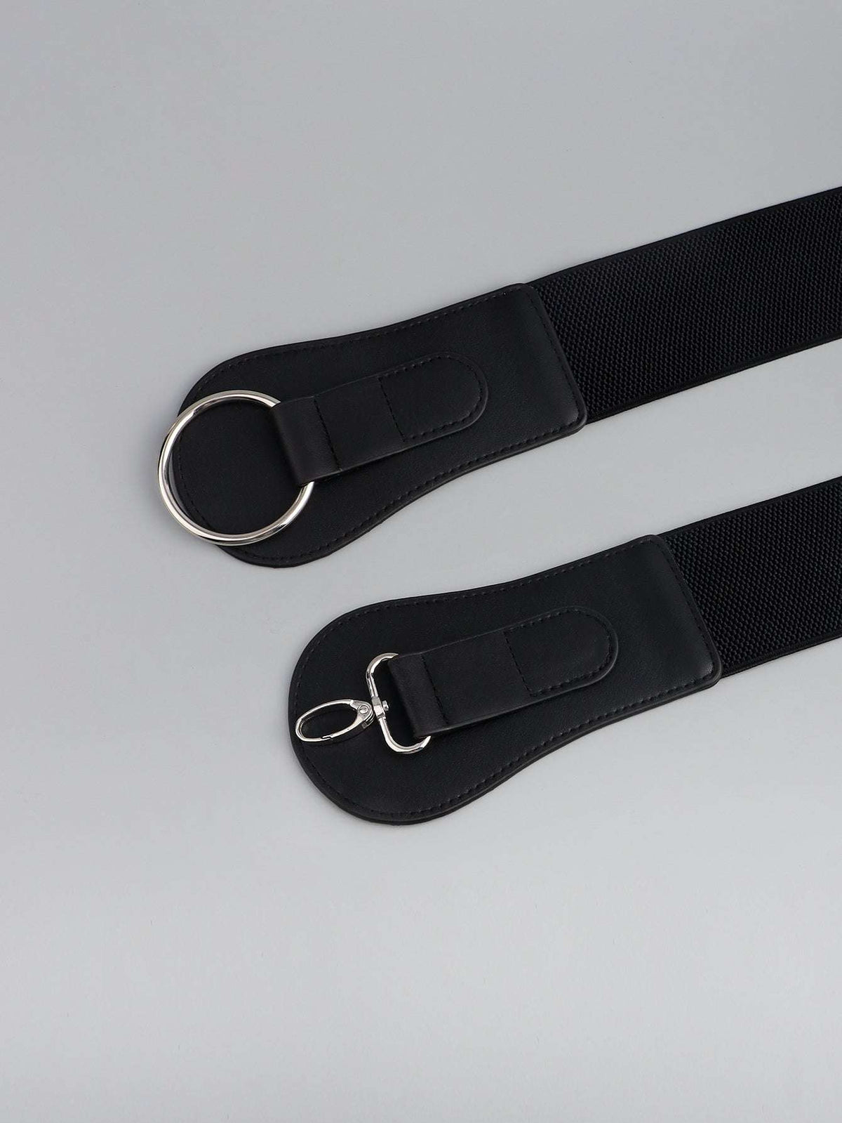 Wide black elastic belt with two ends, oval ring hardware, and stitched leather trim