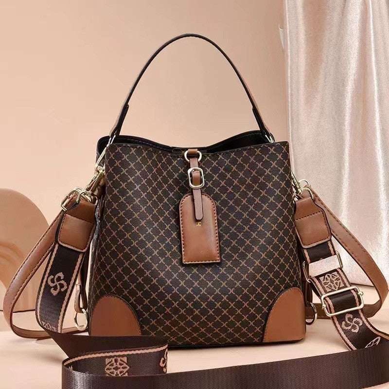 A large capacity handbag for women featuring a plaid pattern with brown leather accents, a bucket shape, and a shoulder strap.