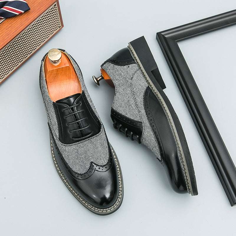 Pair of black and gray patterned dress shoes on a light gray background