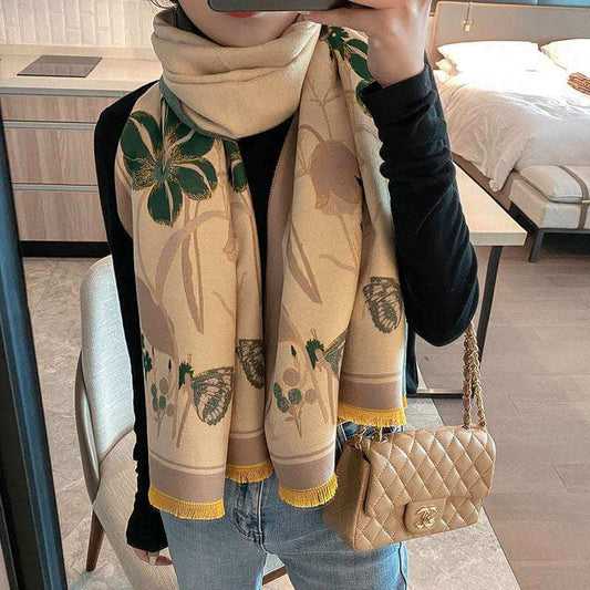 Person wearing a floral scarf and holding a Chanel handbag in a room.