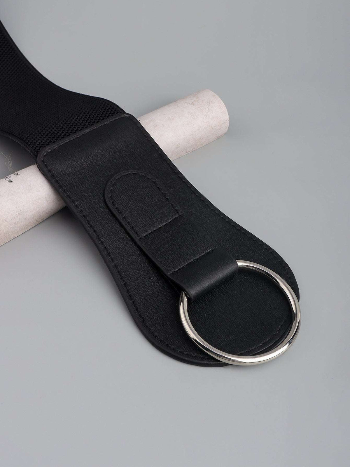 Black PU elastic belt end detail with oval ring and stitched leather patch