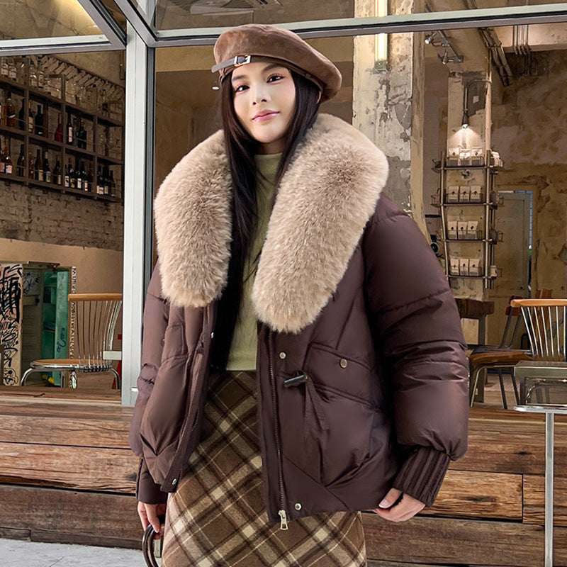 Woman wearing a brown coat with fur collar in a cafe setting