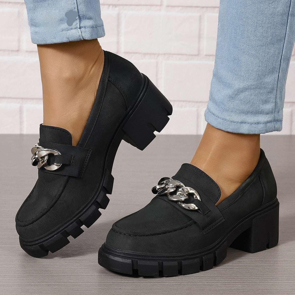Black chunky heel loafers with silver chain buckle detail and thick rubber sole