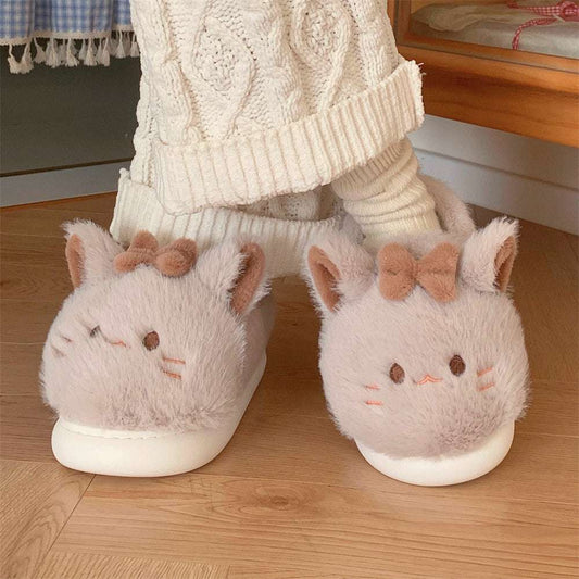 A pair of female slippers designed to look like cartoon cats with white and brown colors and cute facial features.