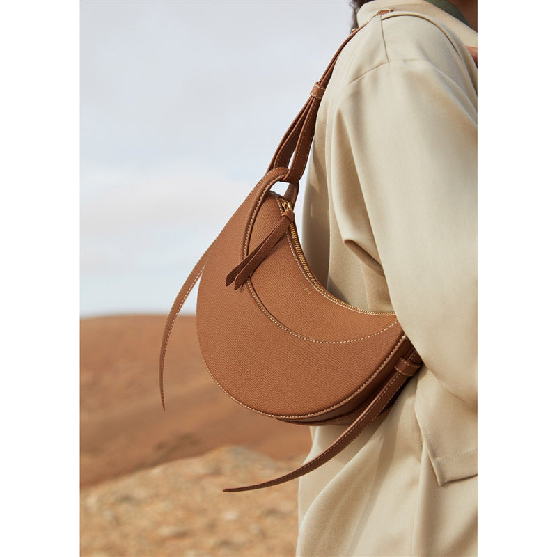 A brown genuine leather shoulder bag with a lychee pattern being