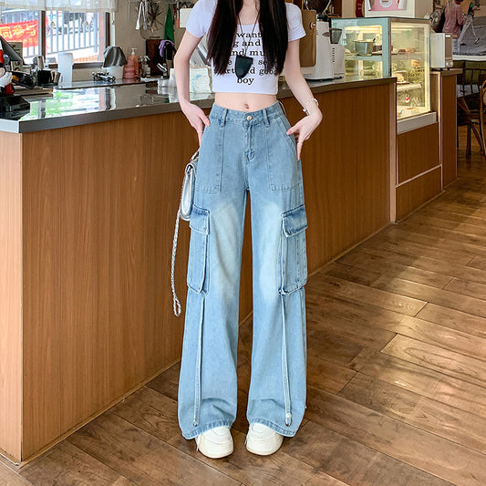 A tall woman modeling floor-length straight-leg trousers with large utility-style front pockets, styled with a cropped sweater and platform boots.