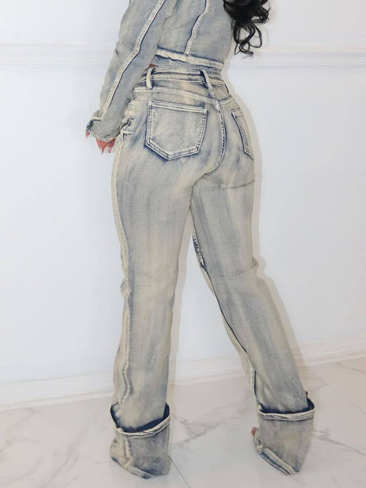 A woman modeling form-fitting washed blue denim pants featuring high-stretch fabric and stylish exposed zipper details on the pockets and cuffs.