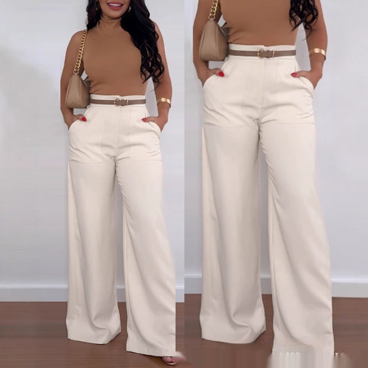 A woman modeling high-waisted solid black flared pants with a smooth, minimalist design and a wide bell-bottom leg opening.