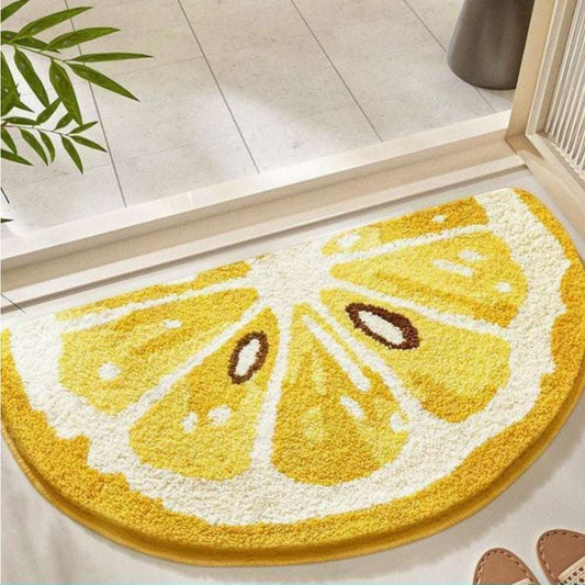 Bright yellow lemon-shaped plush bath mat on a white tiled bathroom floor