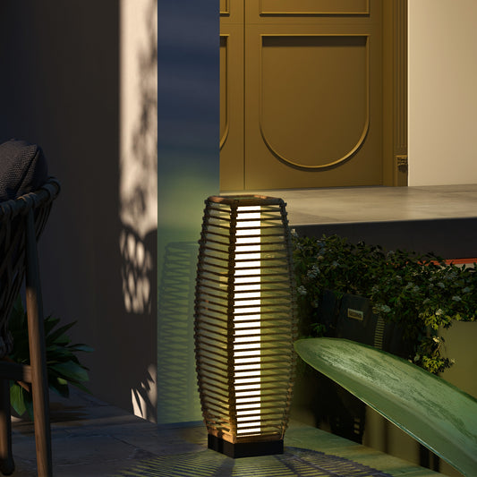 Decorative rattan solar floor lamp with warm LED light illuminating a garden pathway at night
