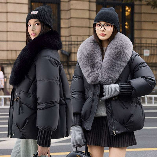 Two women wearing winter coats with fur collars on a street.