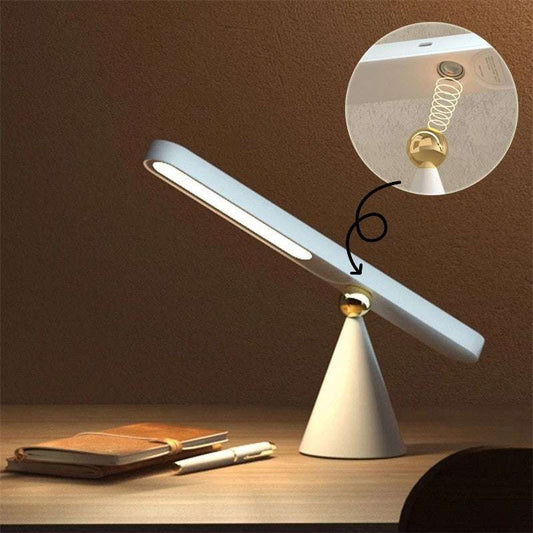 Modern desk lamp with adjustable arm on a wooden surface, close-up of light bulb included.
