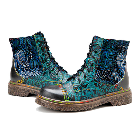 A pair of malachite green hand-painted leather flat boots with a floral pattern and flat heels.